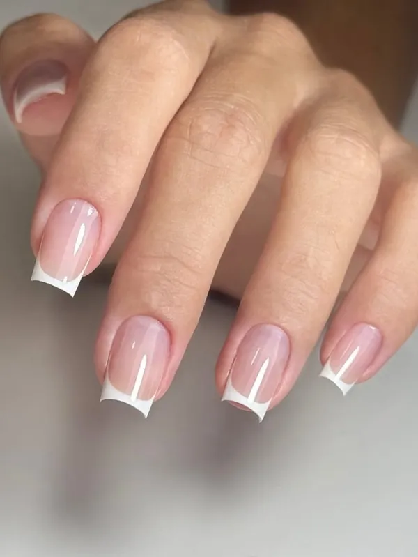 Mão com unhas quadradas curtas em francesinha branca fina