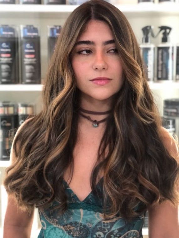 Depois: cabelo longo e ondulado, visto de costas, com mechas loiras douradas e brilho